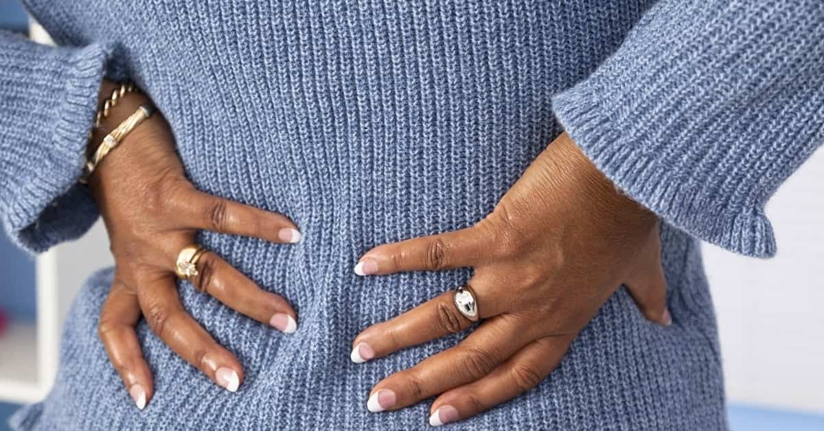 Image of woman's hands on her lower back