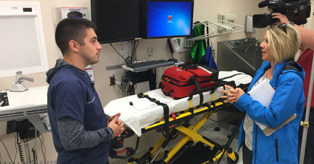 Colton Skenandore, a physician assistant with BayCare Clinic, talks to a TV reporter