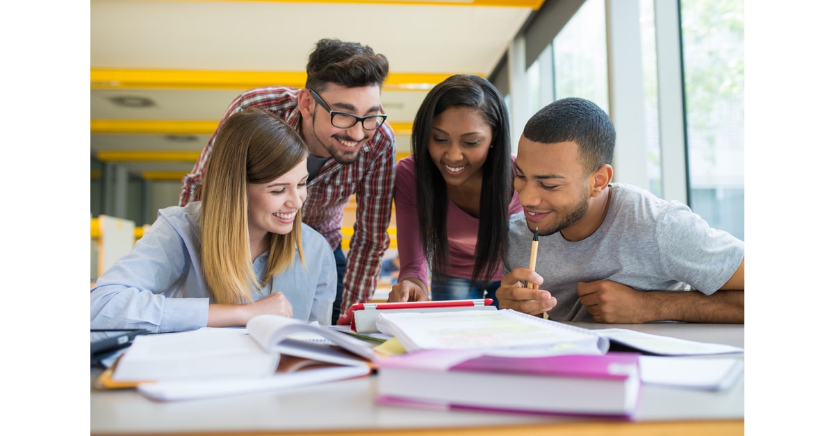 Photo of four students at a table working on a group project