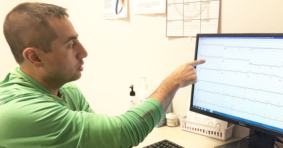 Dr. Armaan Carrigan Shaikh, an Aurora BayCare cardiologist, points to a computer monitor.