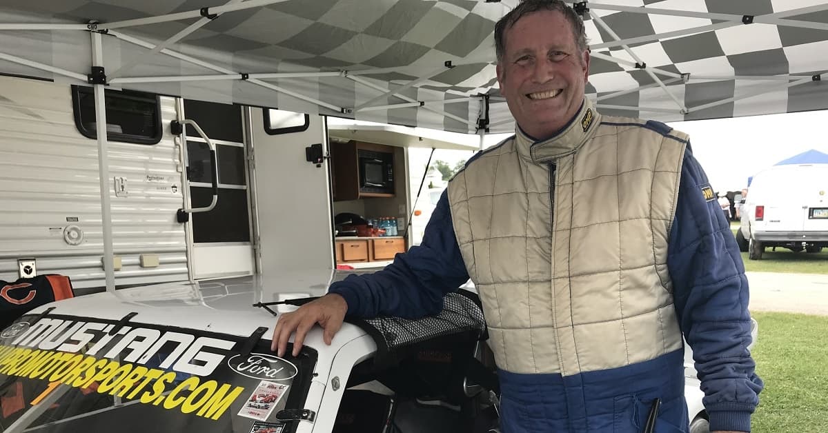 Dr. Craig Olson stands near his race car